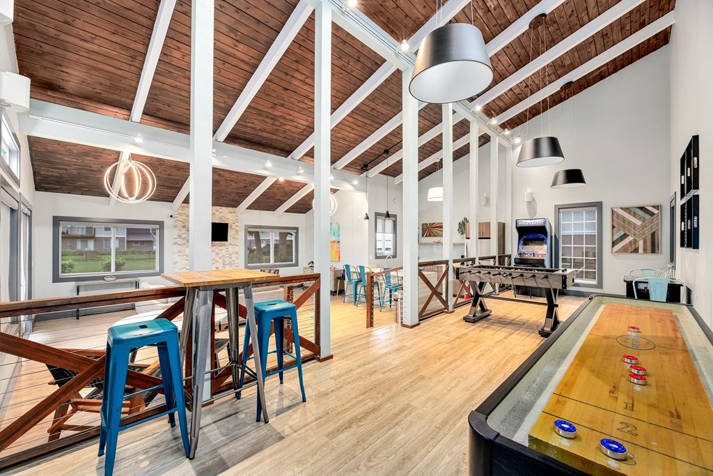 a games room with a shuffleboard table and a ping pong table
