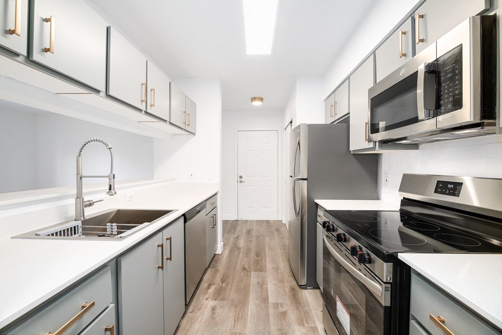 a modern kitchen with white counter tops and stainless steel appliances