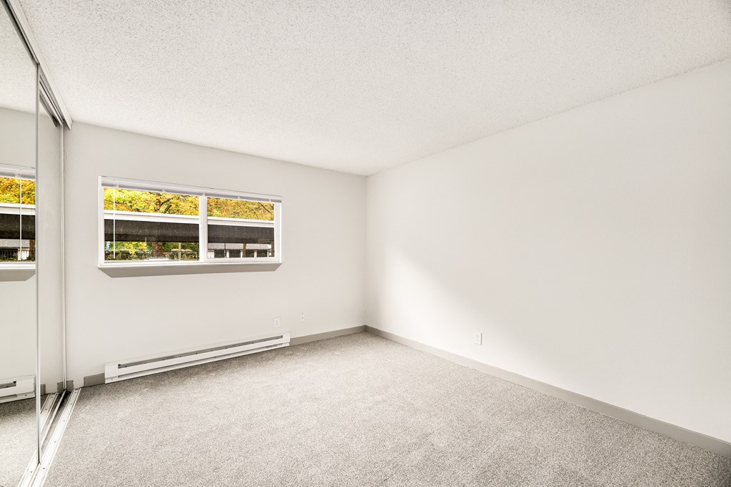 an empty room with white walls and a window