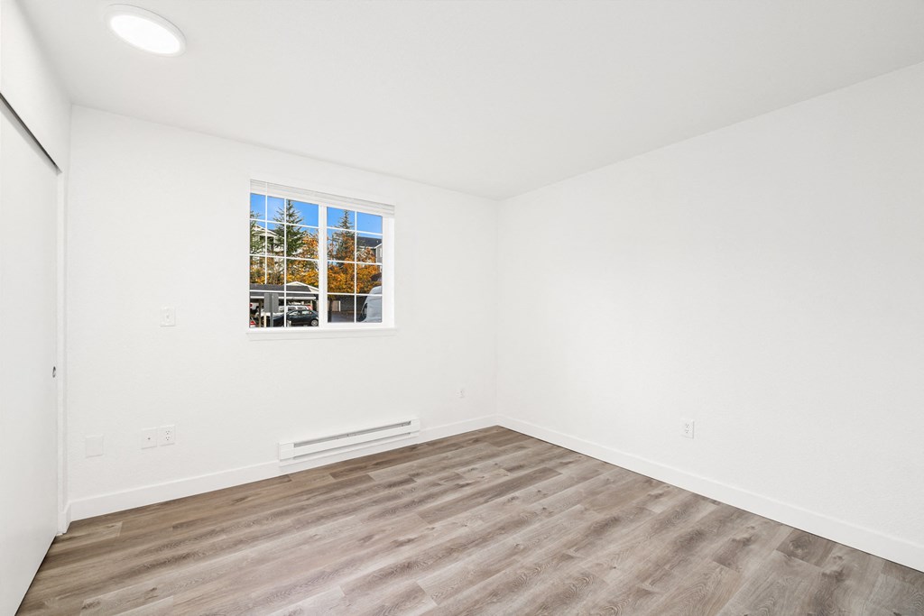 an empty room with white walls and a window