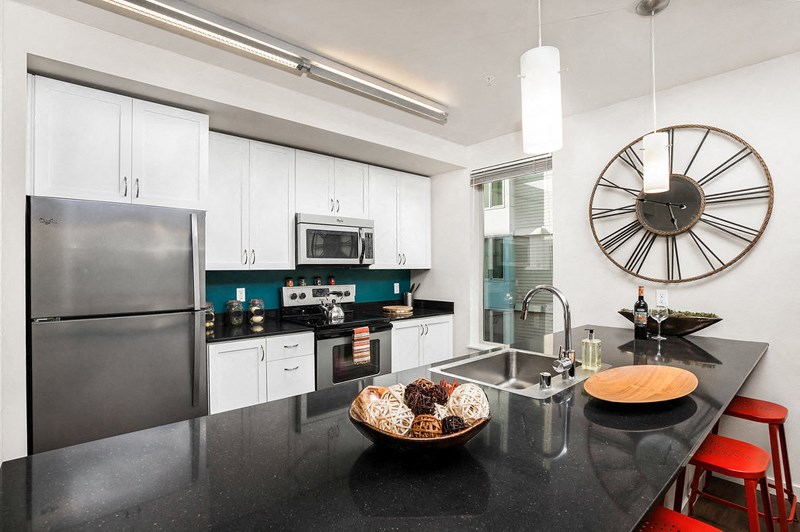 a kitchen with a large clock on the wall