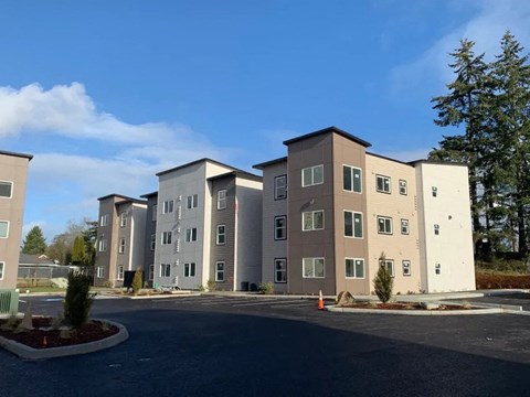 A large building complex with multiple buildings and a parking lot in front.