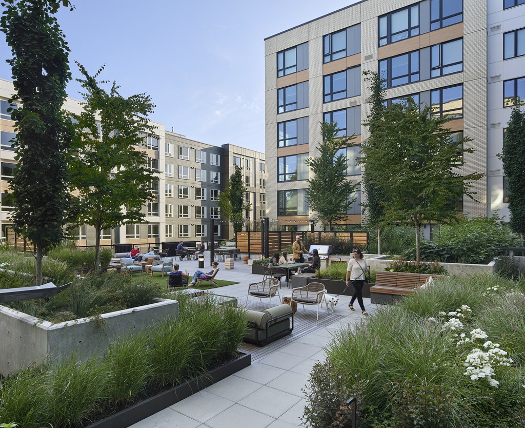A modern courtyard with people walking and sitting.