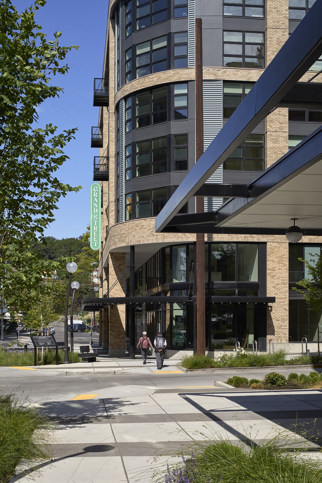 A modern building with a glass facade and a green sign on the side.