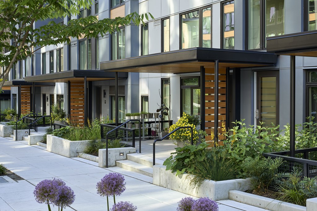 A modern building with a black railing and a white walkway.