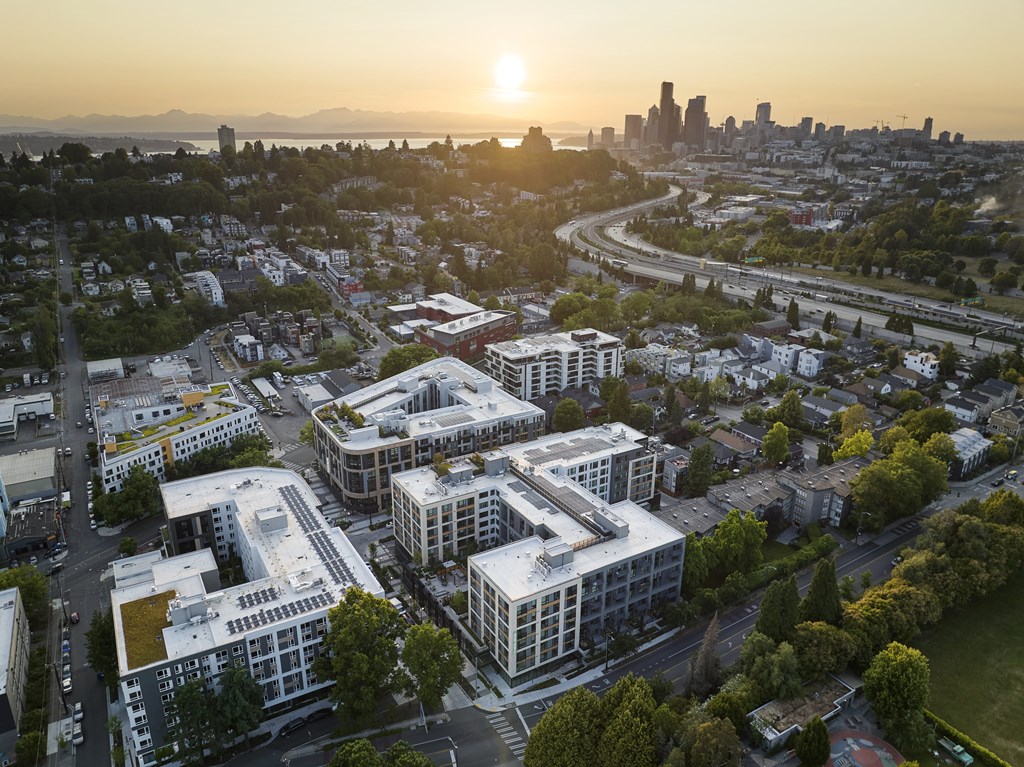A cityscape with buildings and a sunset in the background.