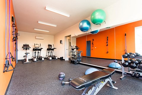 a gym with exercise equipment and balloons on the ceiling