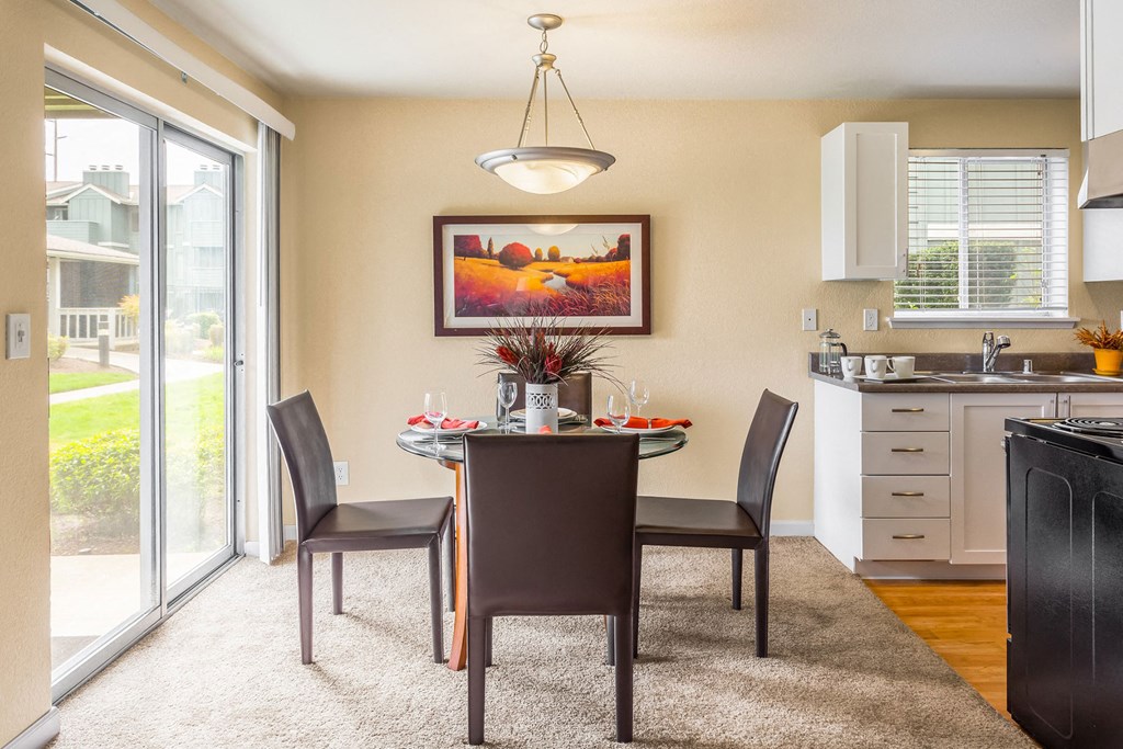a dining room with a table and chairs next to a kitchen