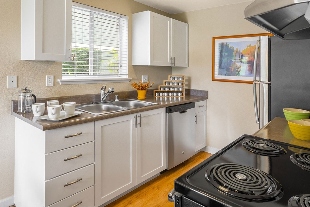 a kitchen with white cabinets and a stove and a sink