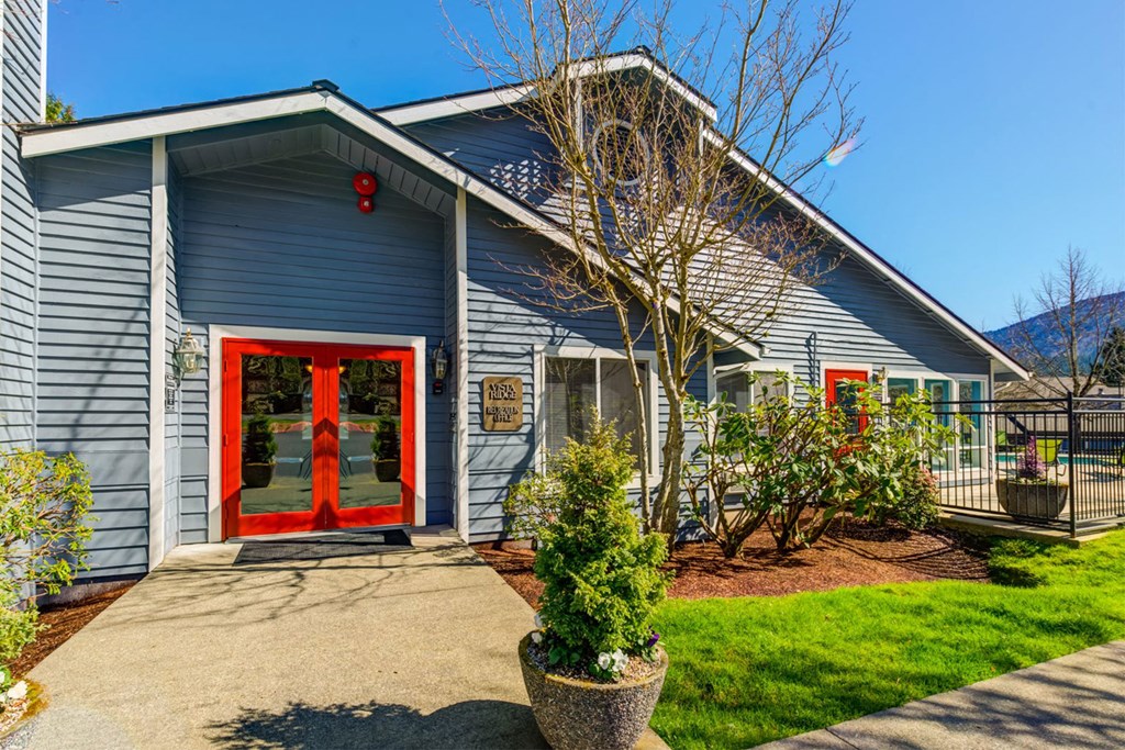 the front of a blue house with a red door
