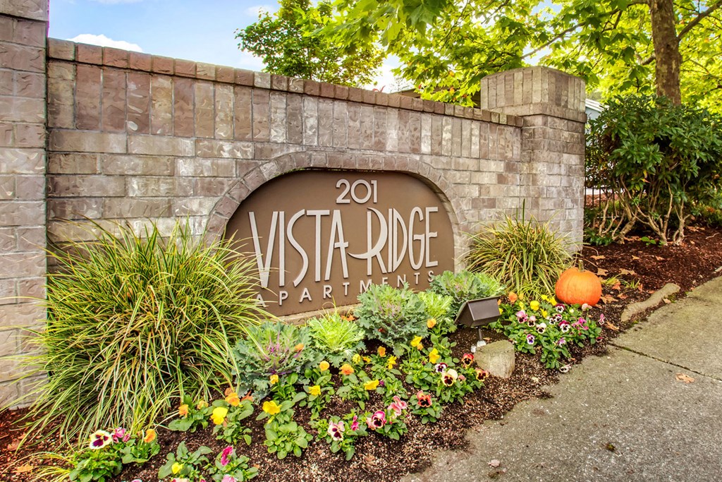 a sign apartments in front of a garden