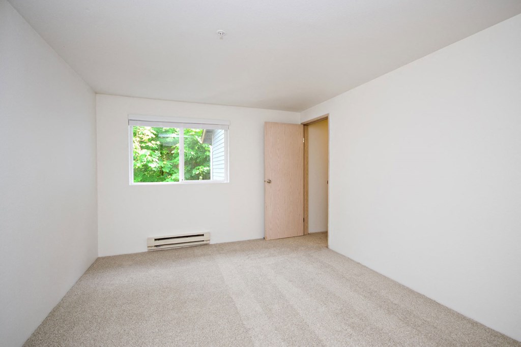 an empty room with a window and a door