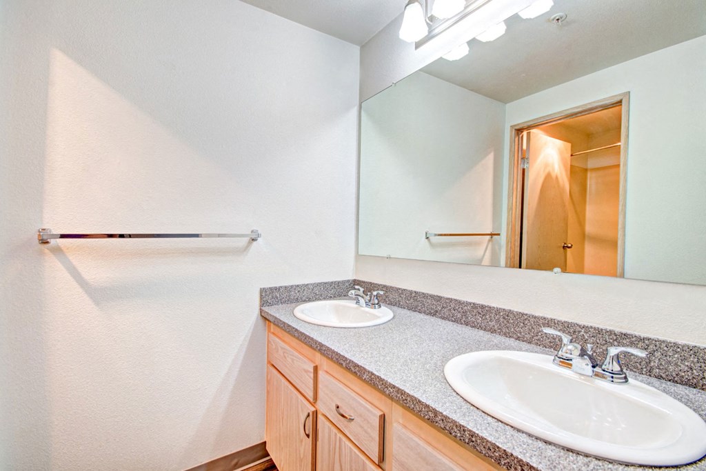 the ensuite bathroom has dual sinks and a large mirror