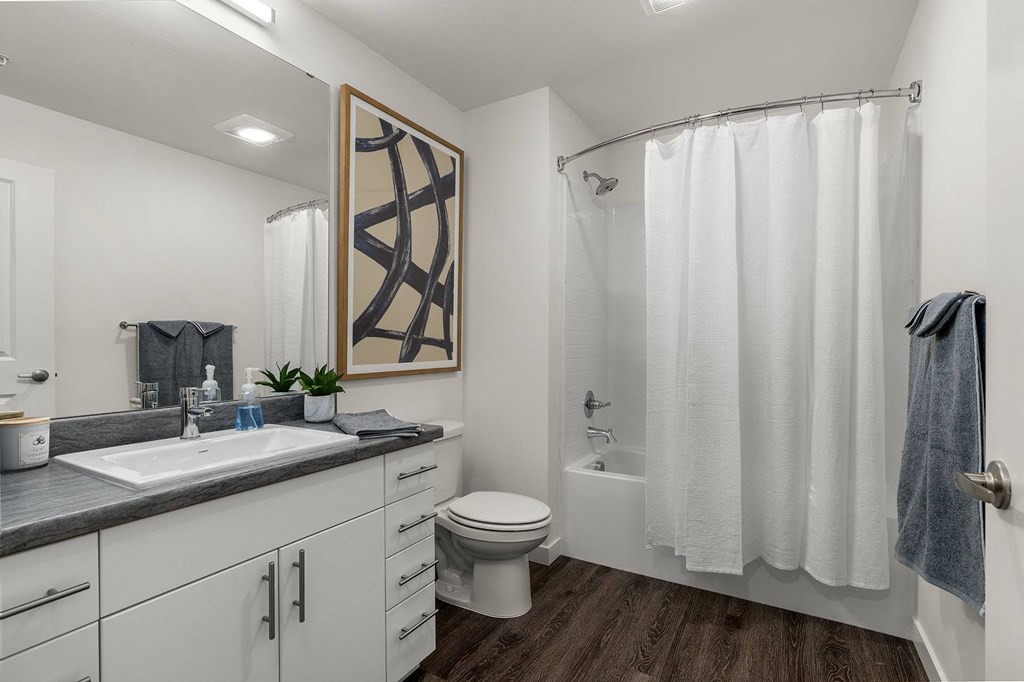 A bathroom with a toilet, sink, and shower.