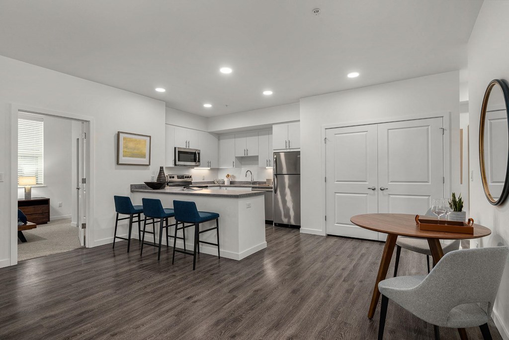 A kitchen with a dining table and chairs.