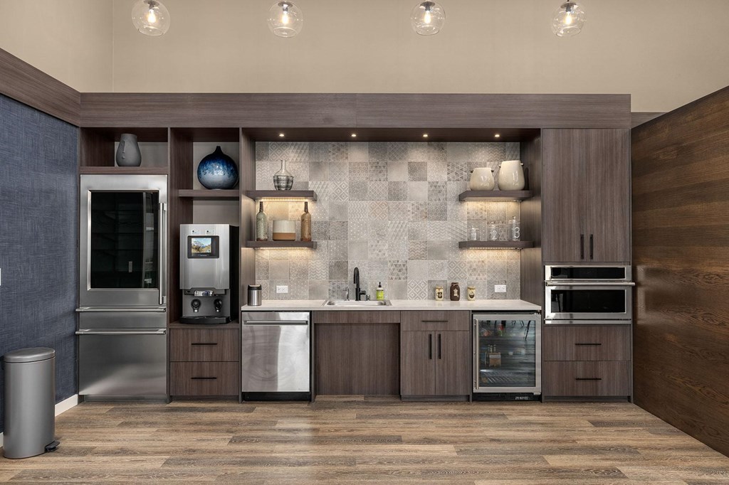 A modern kitchen with dark wood floors and a marble backsplash.