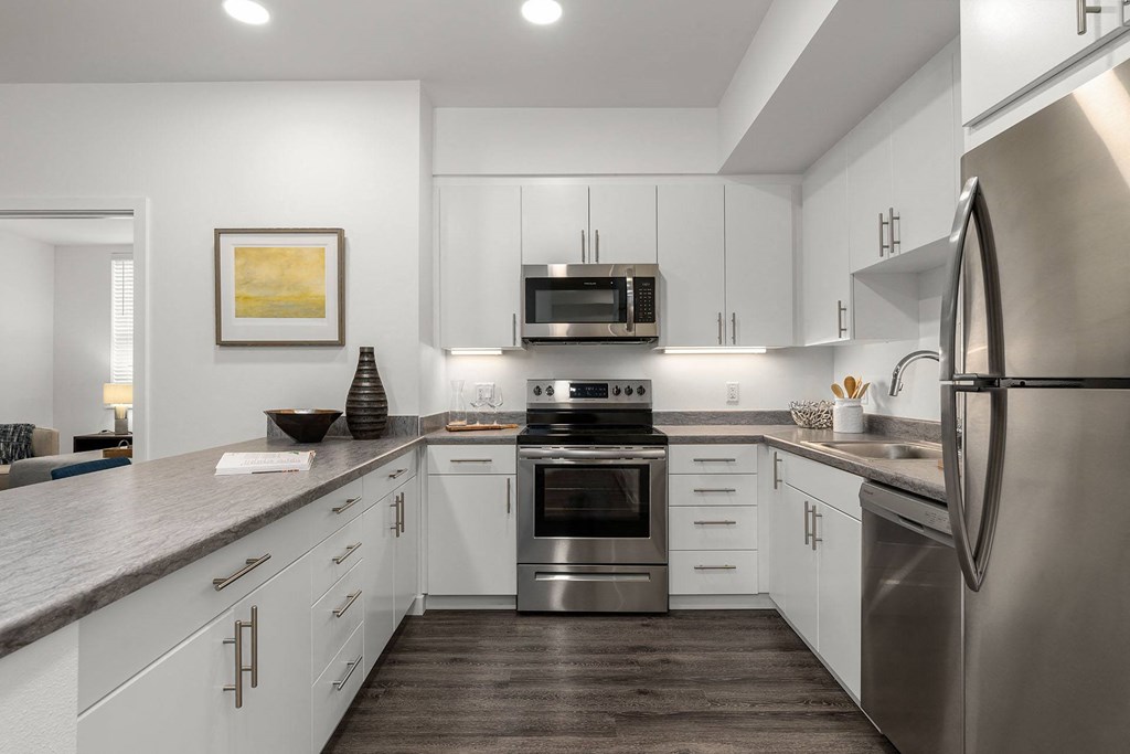 A modern kitchen with stainless steel appliances and white cabinets.