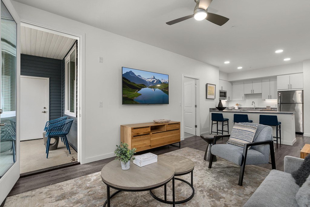 A living room with a flat screen TV mounted on the wall.