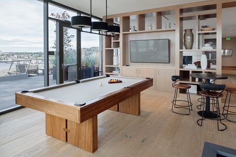 A pool table in a room with a view of the city.