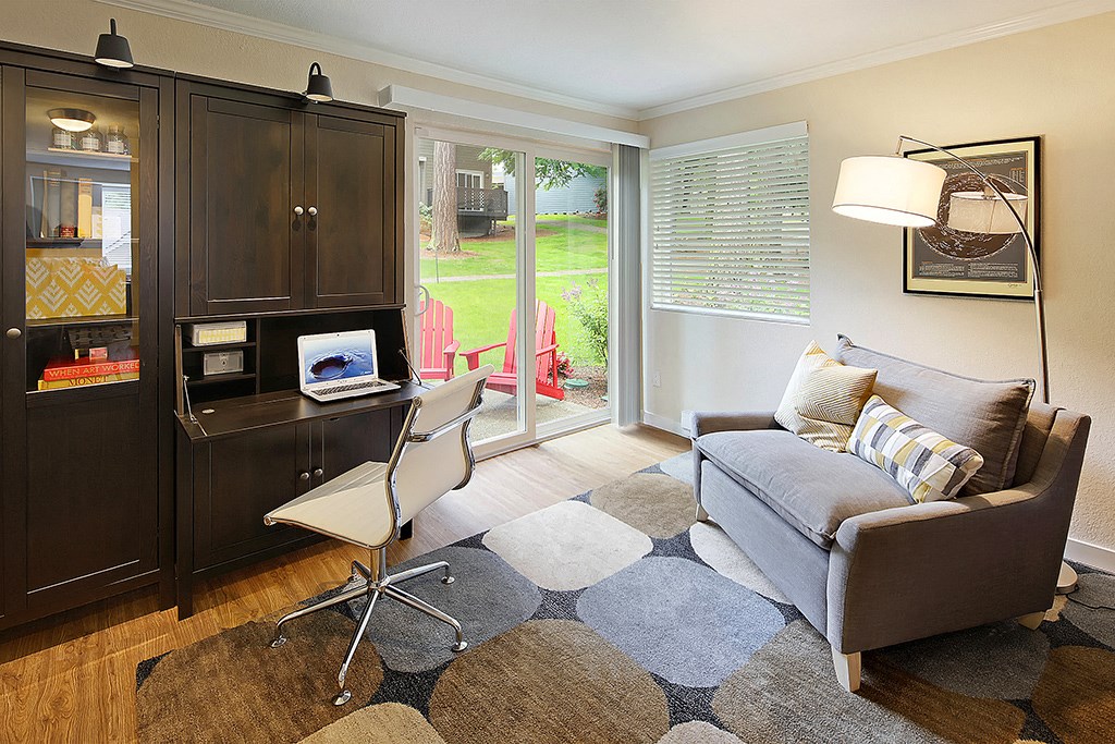 a living room with a couch and a chair and a desk