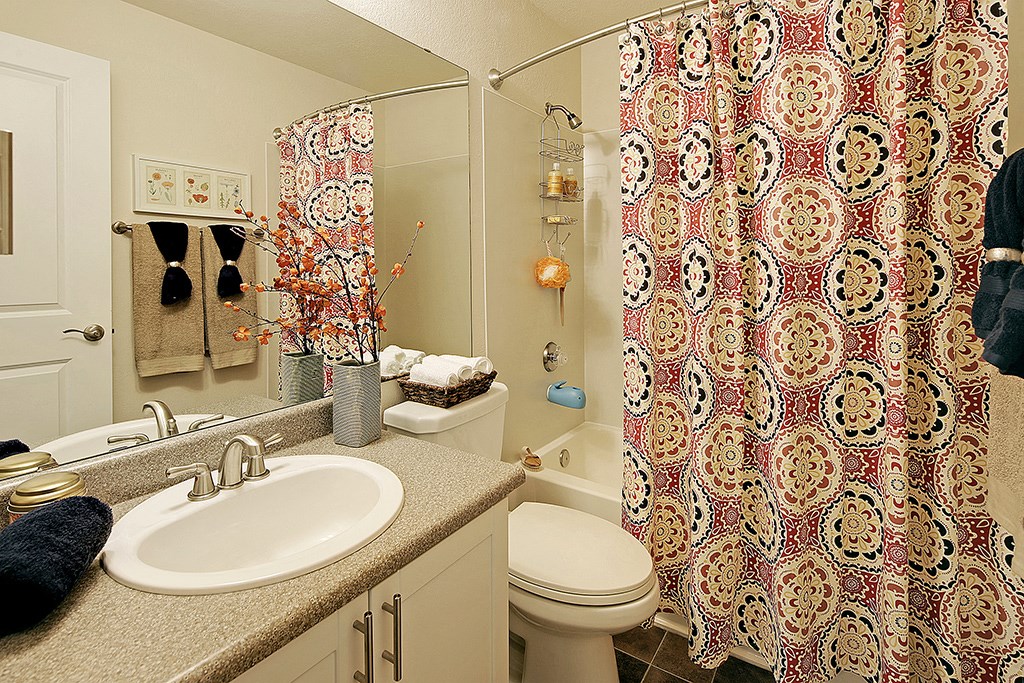 a bathroom with a shower curtain and a sink and a toilet
