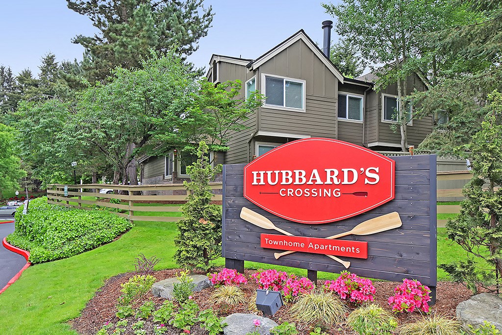 a sign for hubbards crossing in front of a house