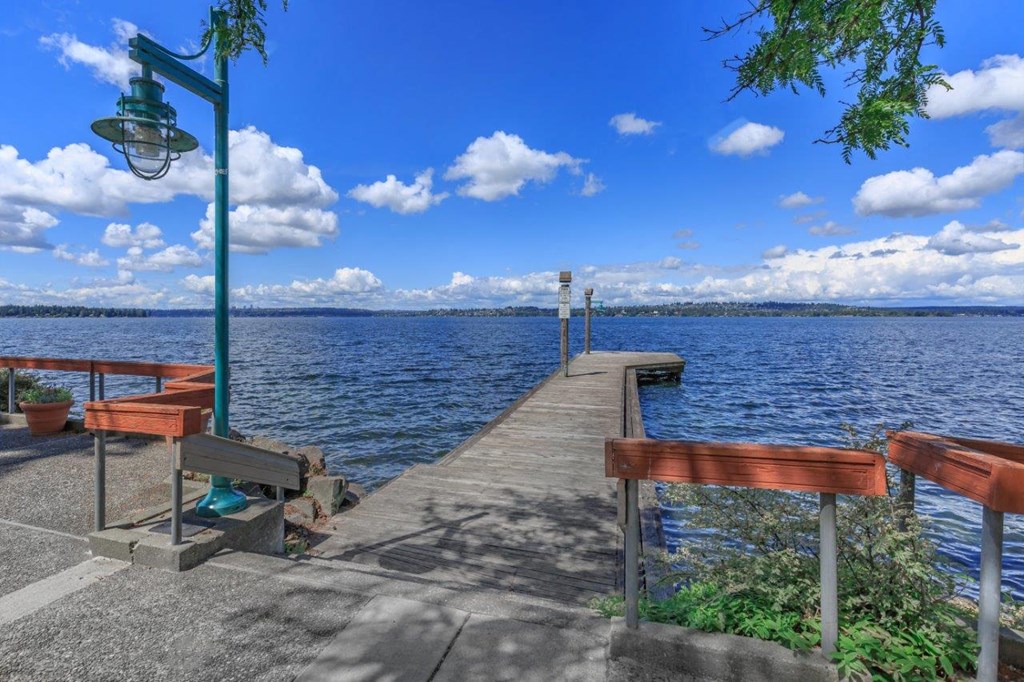 a dock with benches overlooking the water on a sunny day