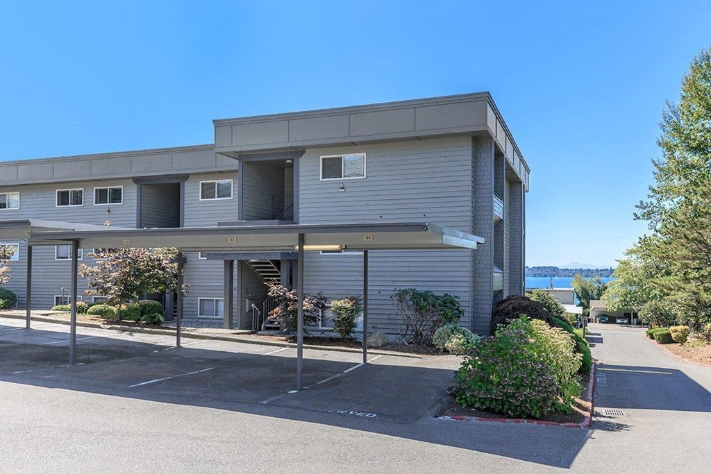 the front of a gray building with a river in the background