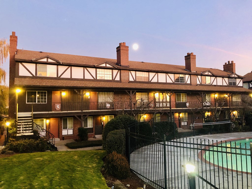 a large building with a pool and a fence
