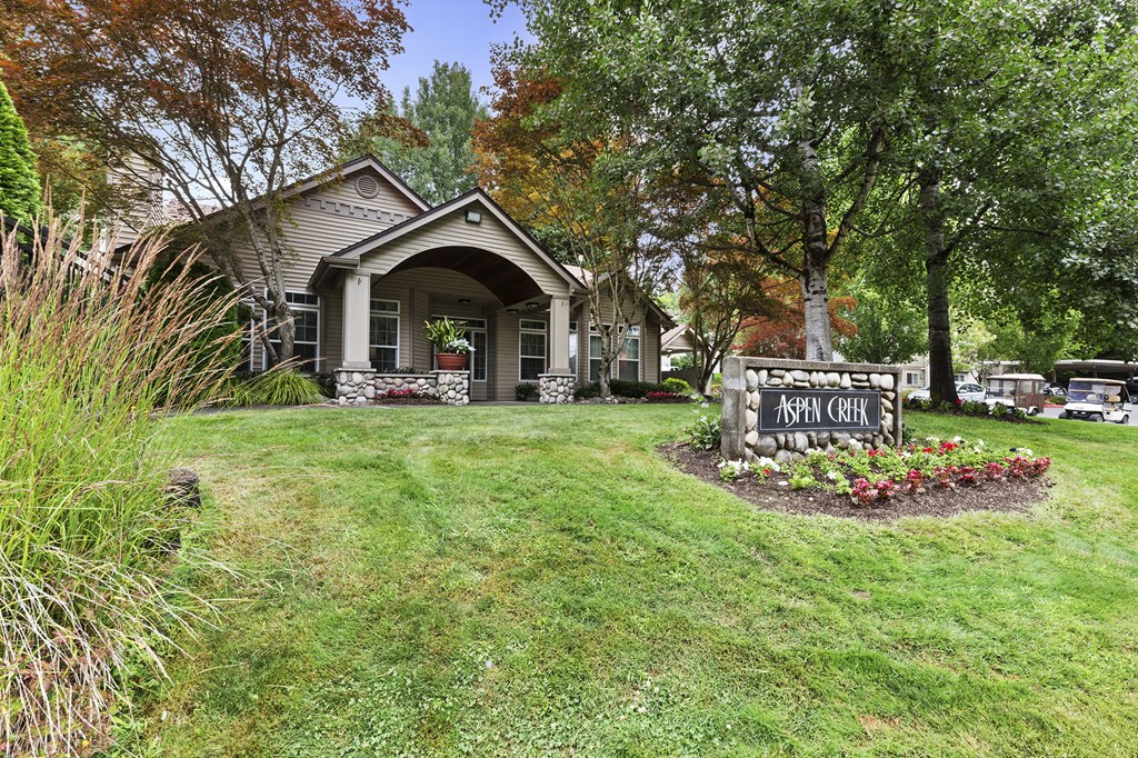a house with a sign in front of it on a lawn