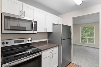 a kitchen with stainless steel appliances and white cabinets