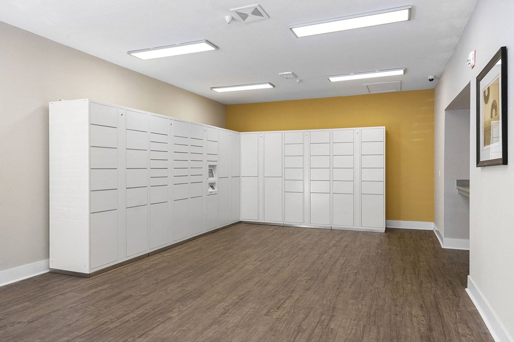 an empty room with white lockers and a yellow wall