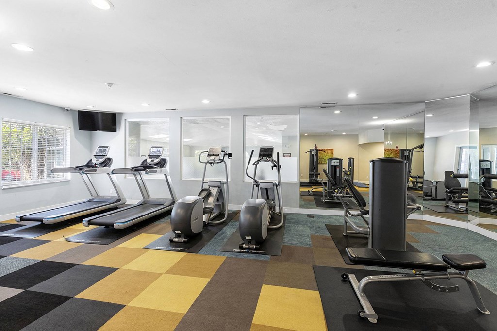 a gym with treadmills and other exercise equipment on a checkered floor