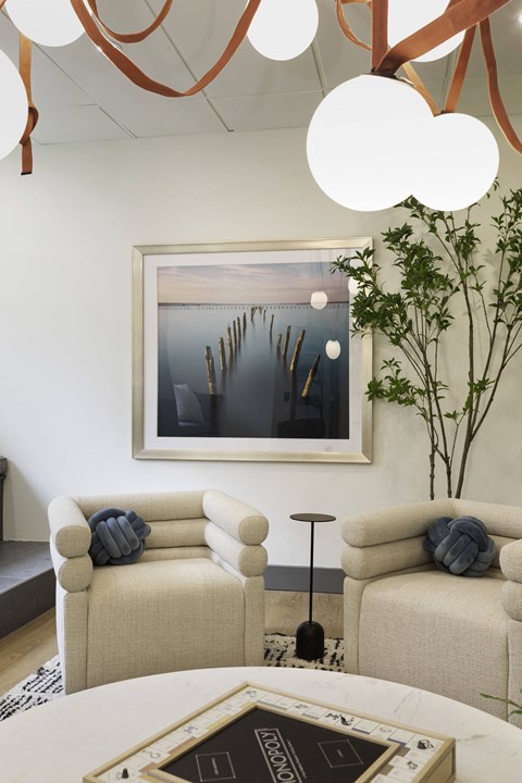 A living room with a painting on the wall and two couches.