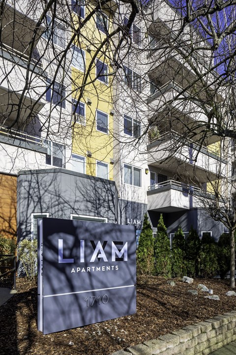 an apartment building with a sign in front of it
