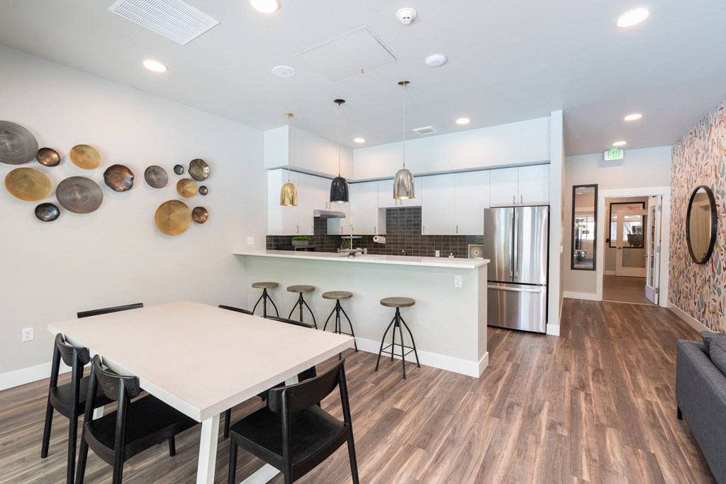 a kitchen and dining room with a white table and stools