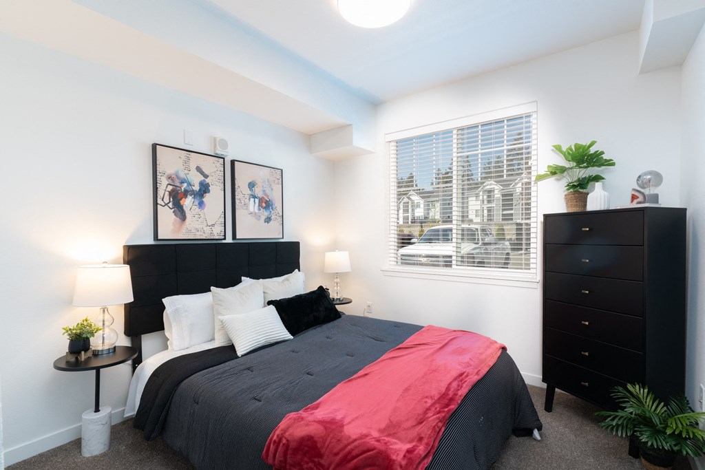 a bedroom with a bed and a dresser and a window