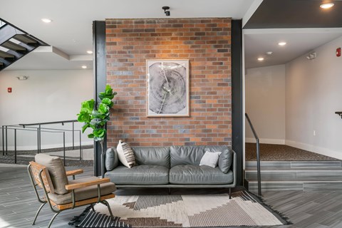 A living room with a grey couch and a wooden chair.