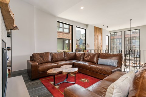 A brown leather couch with a white pillow is in the middle of a room.