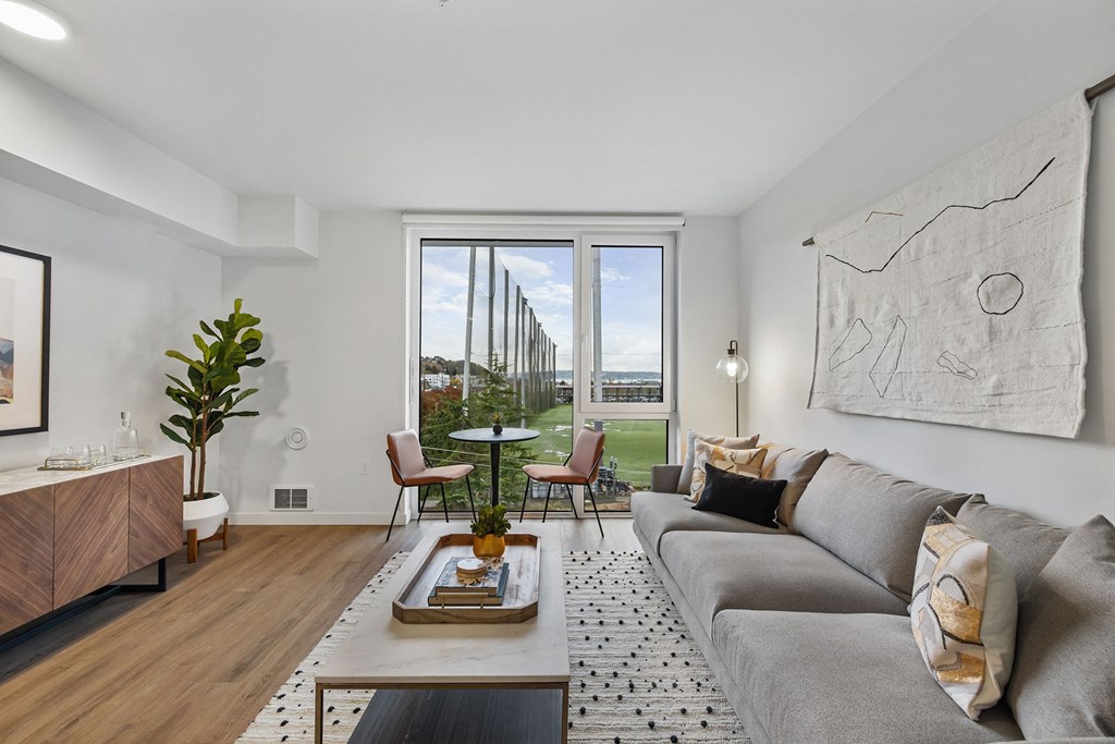 a living room with a couch and a coffee table and a window