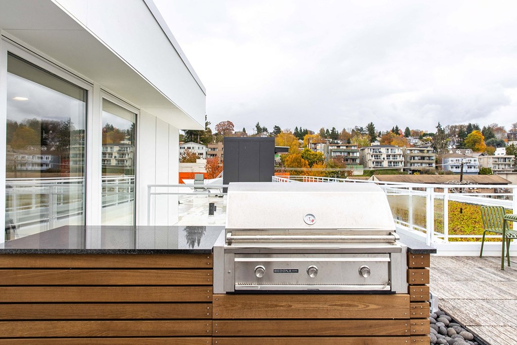 a stainless steel barbecue grill on a deck with a city view