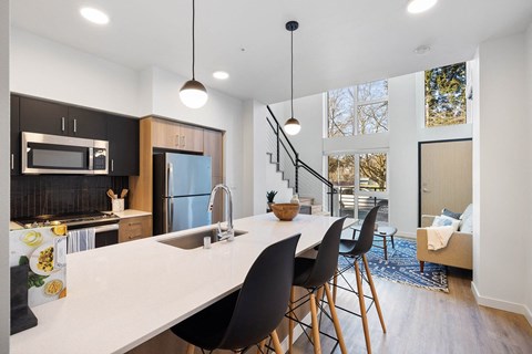 an open kitchen and living room with a white counter top