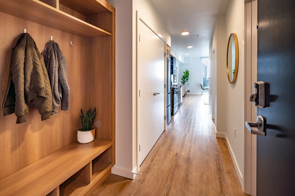a hallway with a door to a bathroom and a closet with towels