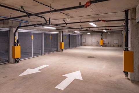a empty parking garage with doors and arrows on the floor