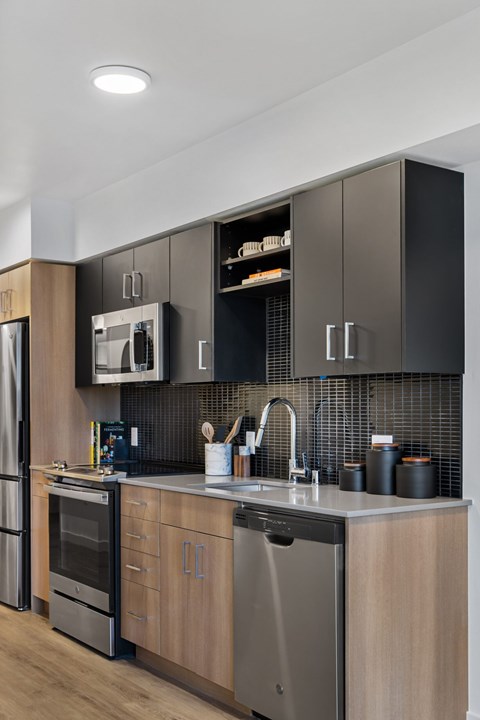 A modern kitchen with dark brown cabinets and stainless steel appliances.