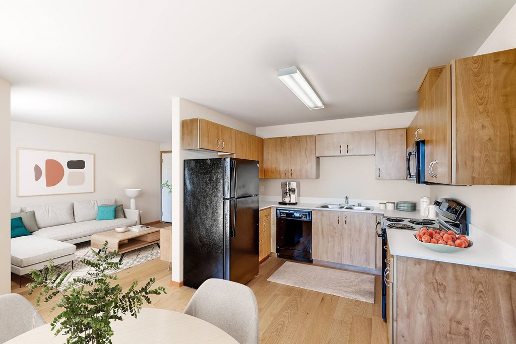 A modern kitchen with a refrigerator, oven, and sink.