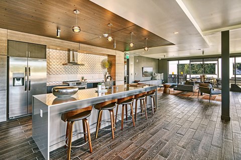 A modern kitchen with a long island and wooden floors.