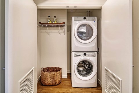 A white washing machine is in a small laundry room.