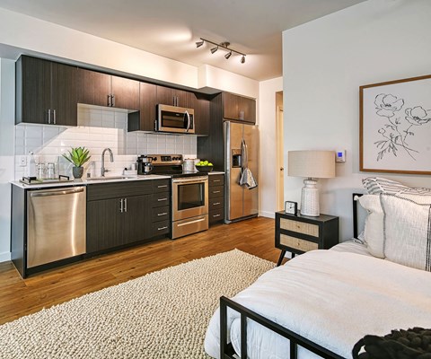 A modern kitchen with dark wood cabinets and stainless steel appliances.