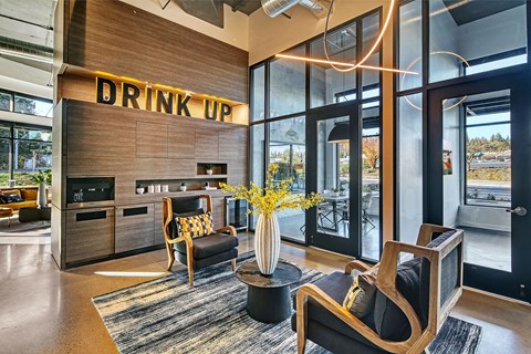 A room with a sign that says "DRINK UP" on the wall.
